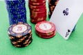 Stack of poker chips next to a card with an ace on a green game table Royalty Free Stock Photo